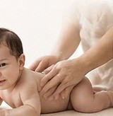 A baby lying on a soft surface during massage